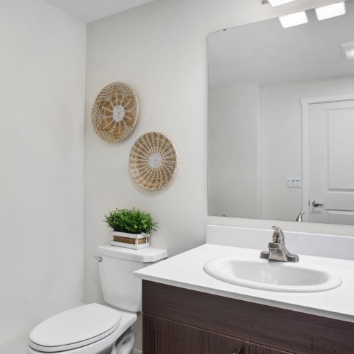 Affordable Apartments in San Jose CA - Virginia Street Studios - A Bright And Spacious Bathroom With Dark Cabinetry, White Countertops, And A Single Sink Vanity Affordable Apartments in San Jose CA - Virginia Street Studios - A Bright And Spacious Bathroom With Dark Cabinetry, White Countertops, And A Single Sink Vanity